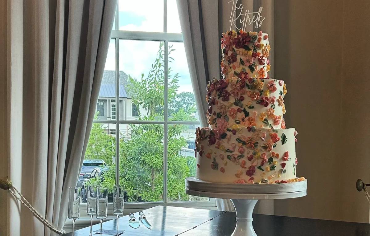 Four-tier floral wedding cake by window