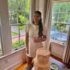 Woman in white dress beside tiered cake