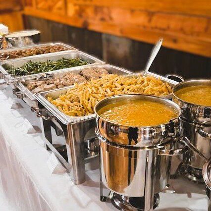 Catered buffet table with soups, pasta, vegetables