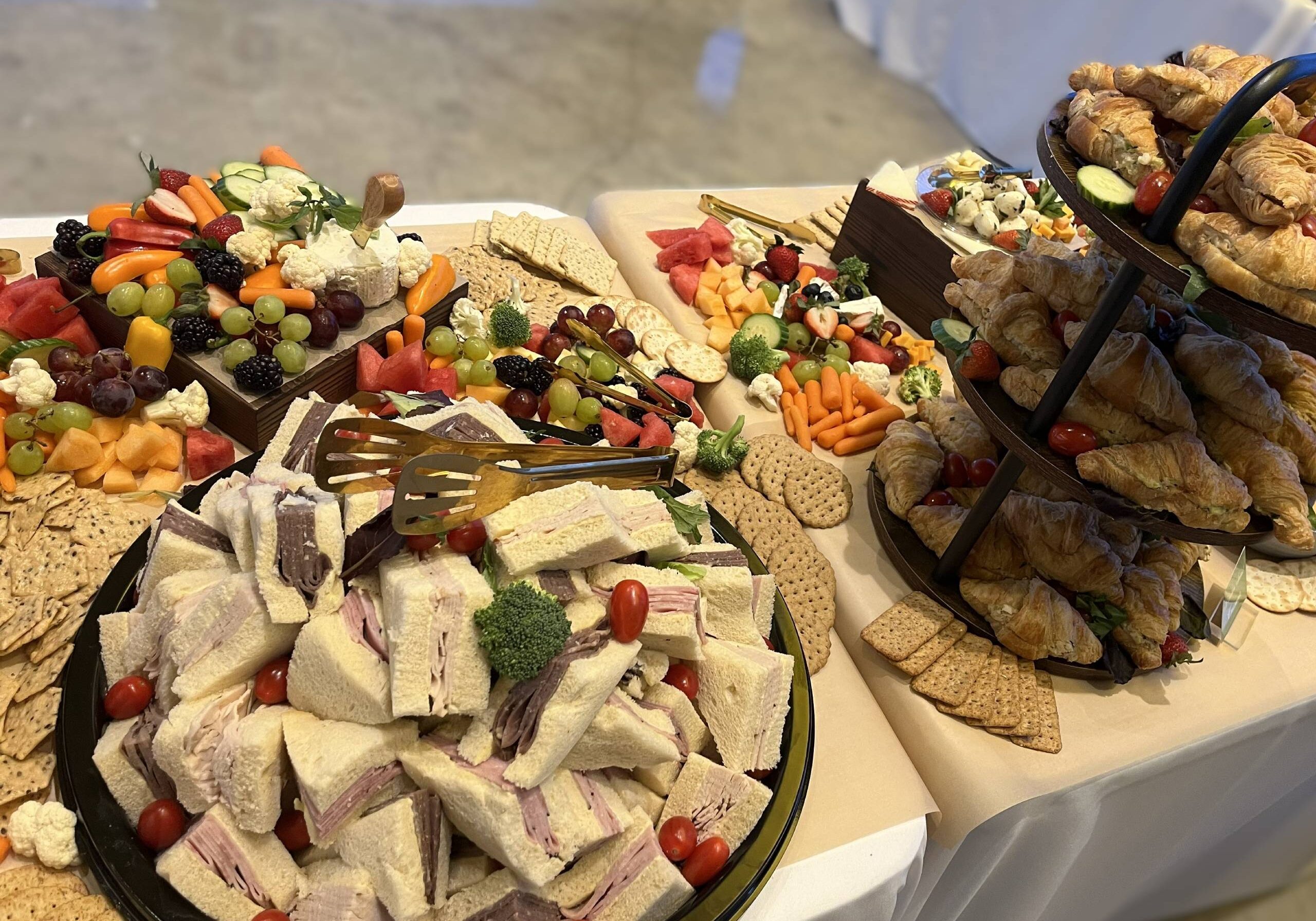 Buffet of sandwiches, croissants, crackers, and fruit